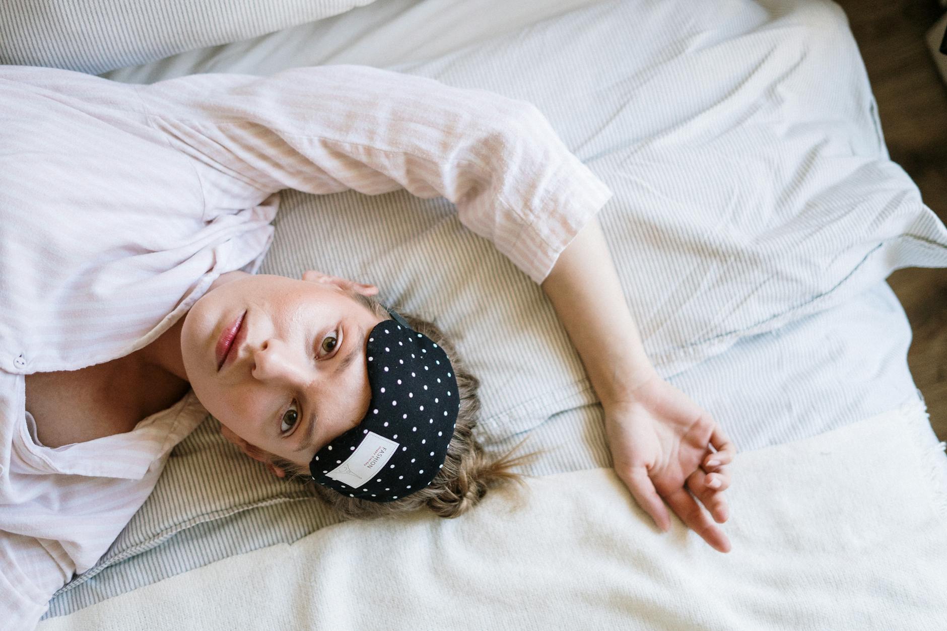 woman in white crew neck t shirt lying on bed