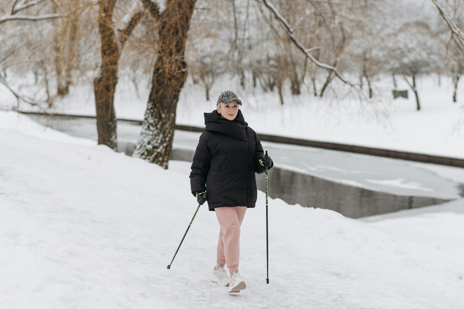 a woman in a black jacket walking on white snow